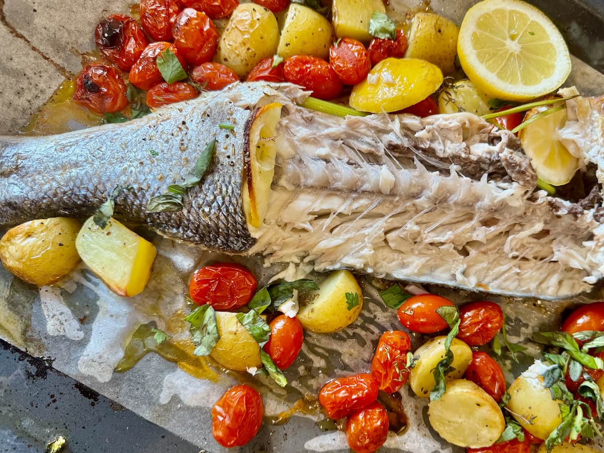 Whole baked sea bass beautifully presented after cooking, showcasing its tender meat