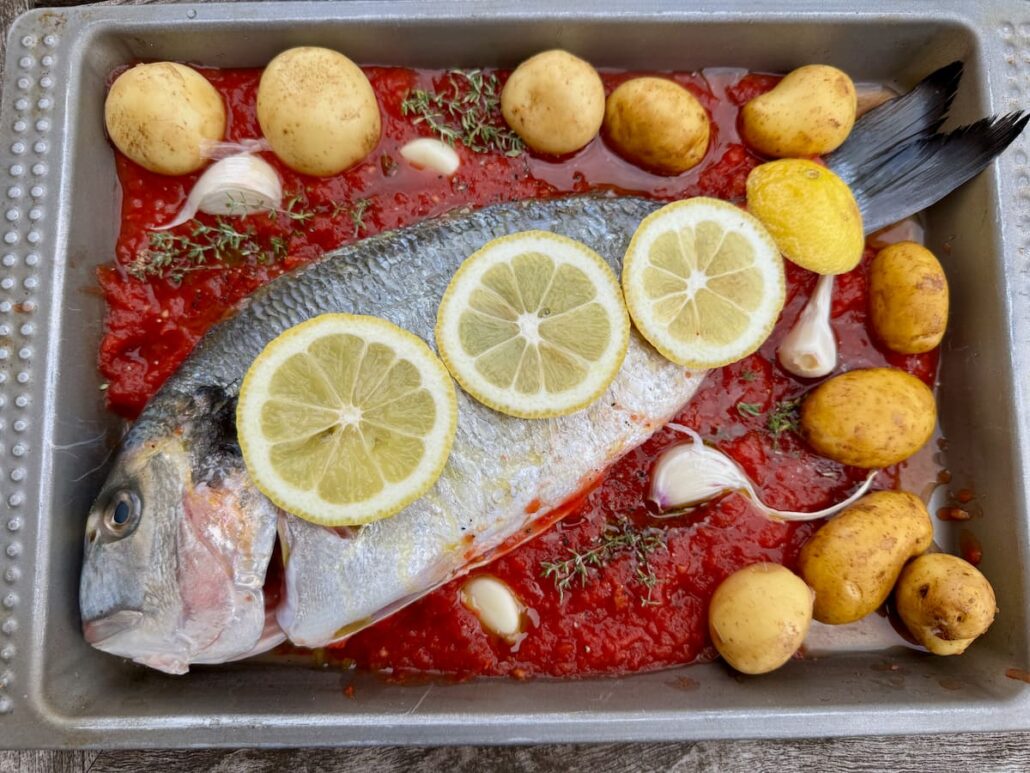 Whole sea bream stuffed with vegetables and topped with lemon slices