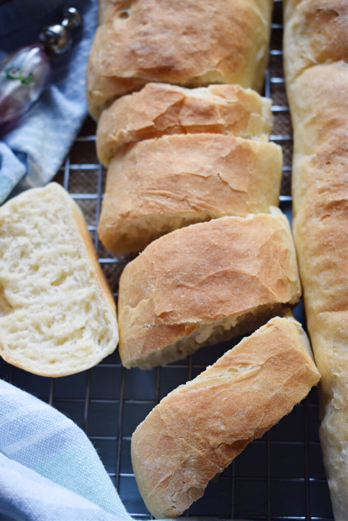 Sliced bread on a tray with a tea towel.
