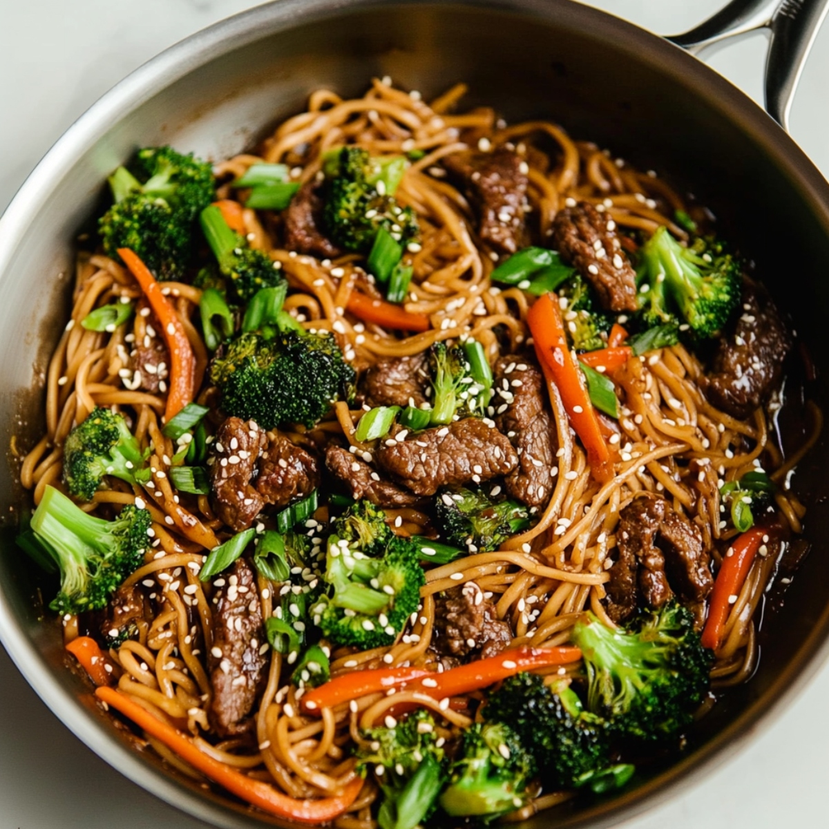 beef and broccoli lo mein in a skillet