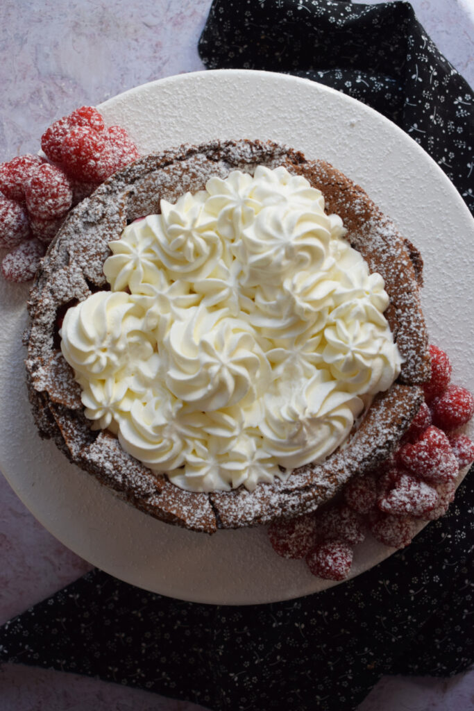 Chocolate torte topped with whipped cream.