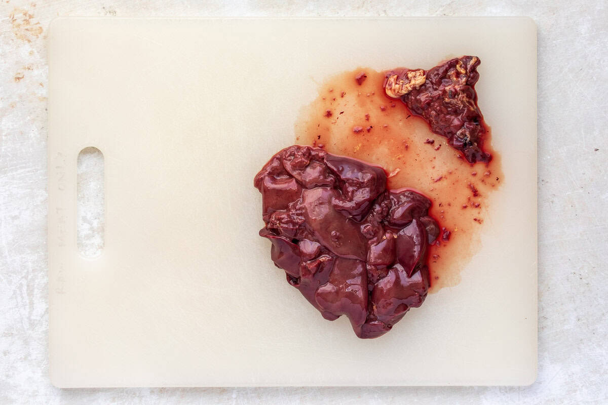 Trimmed chicken livers on cutting board.