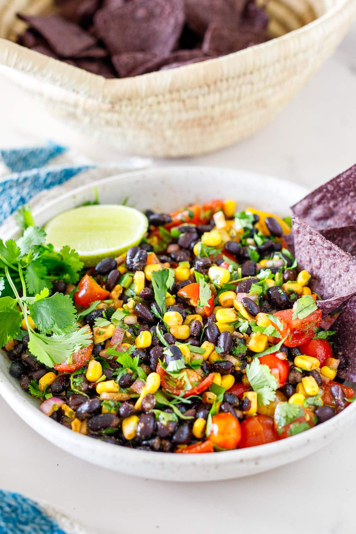Serving bowl filled with black bean salsa, garnished with fresh cilantro and lime.