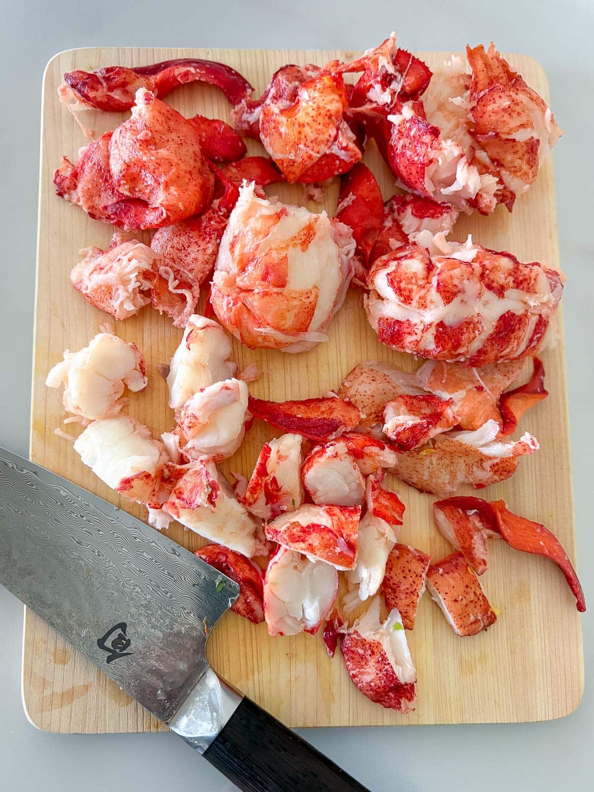 Chopping lobster on a cutting board.