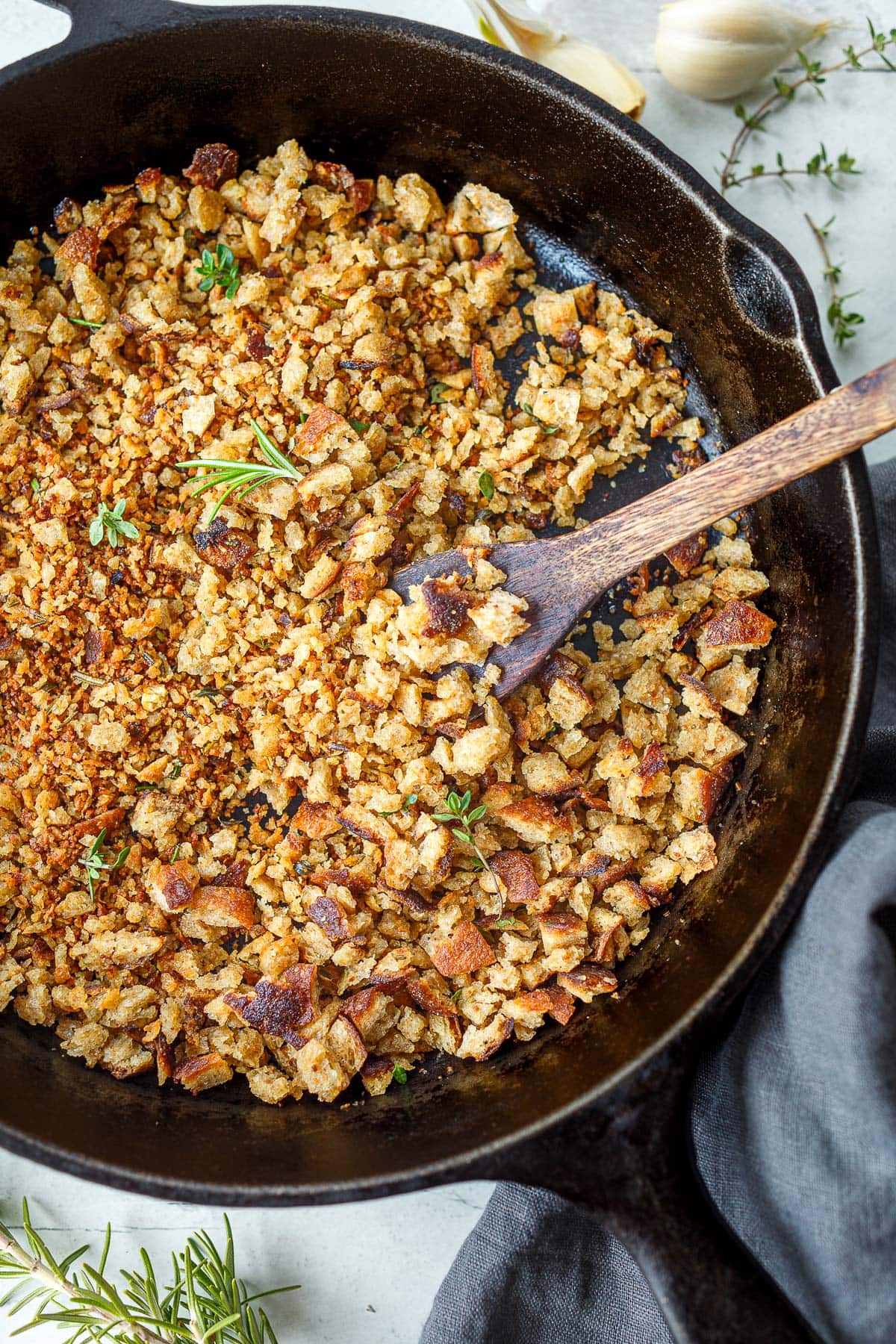 Cast iron skillet with pangrattato topped with fresh herbs