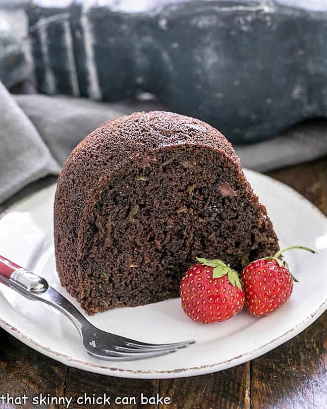 Slice of Chocolate Zucchini Bundt Cake on a white plate.