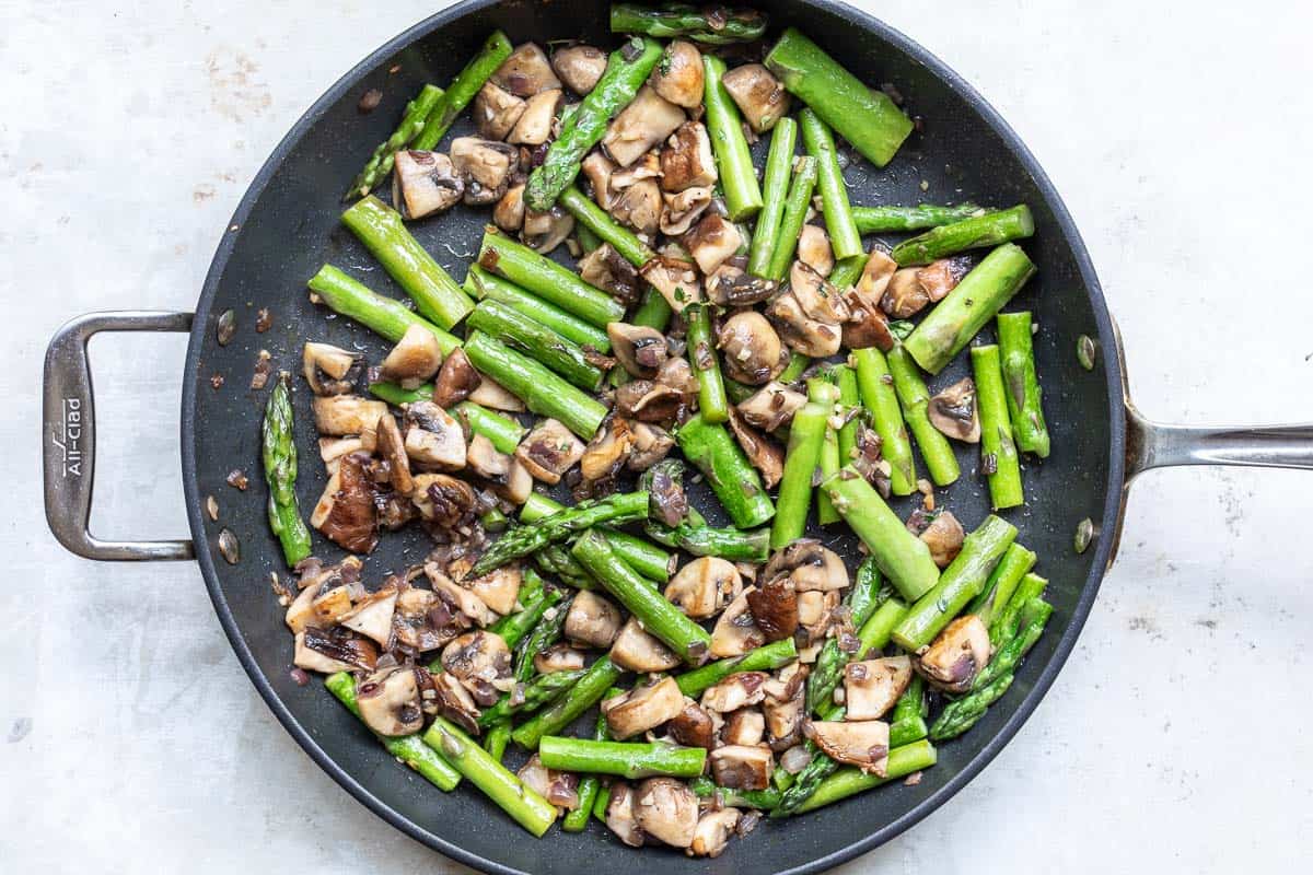 Sautéed asparagus and mushrooms in a skillet