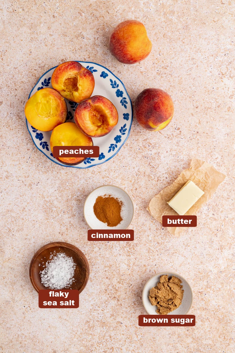 Ingredients for grilled peaches including fresh peaches, butter, brown sugar, cinnamon, and salt.