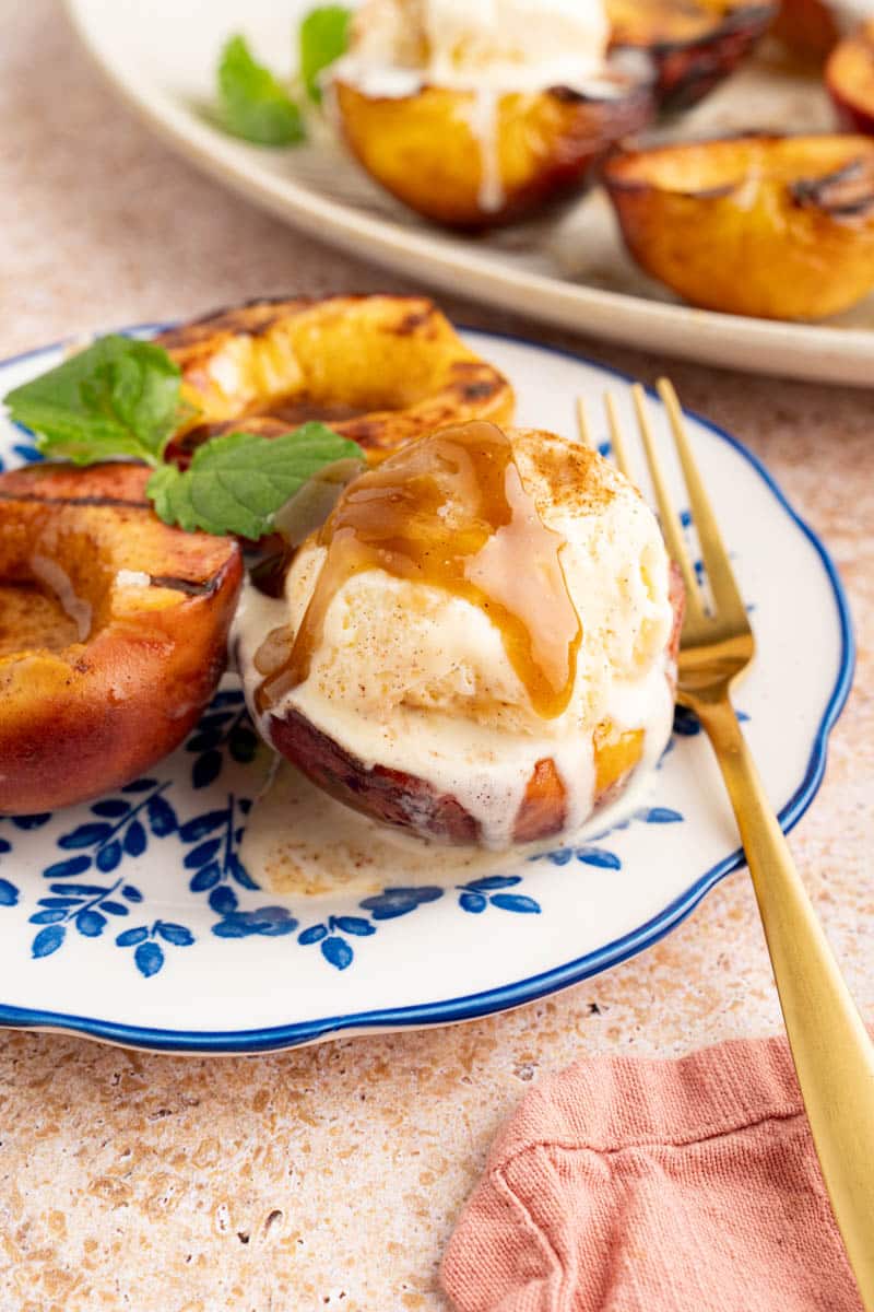 Grilled peaches served with ice cream.