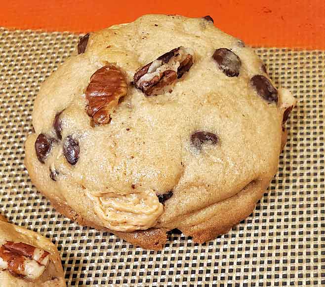One chocolate chip cookie on a Silpat mat