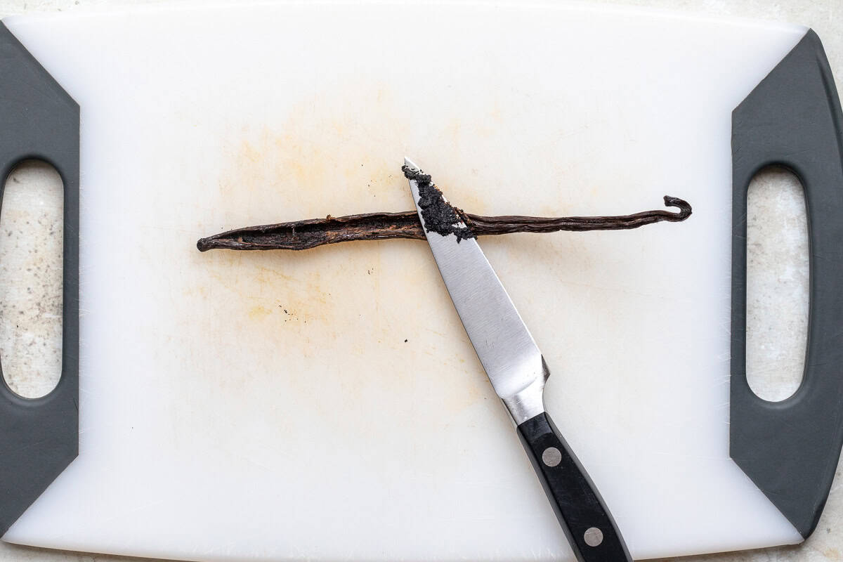 A sliced vanilla bean pod showing vanilla seeds.