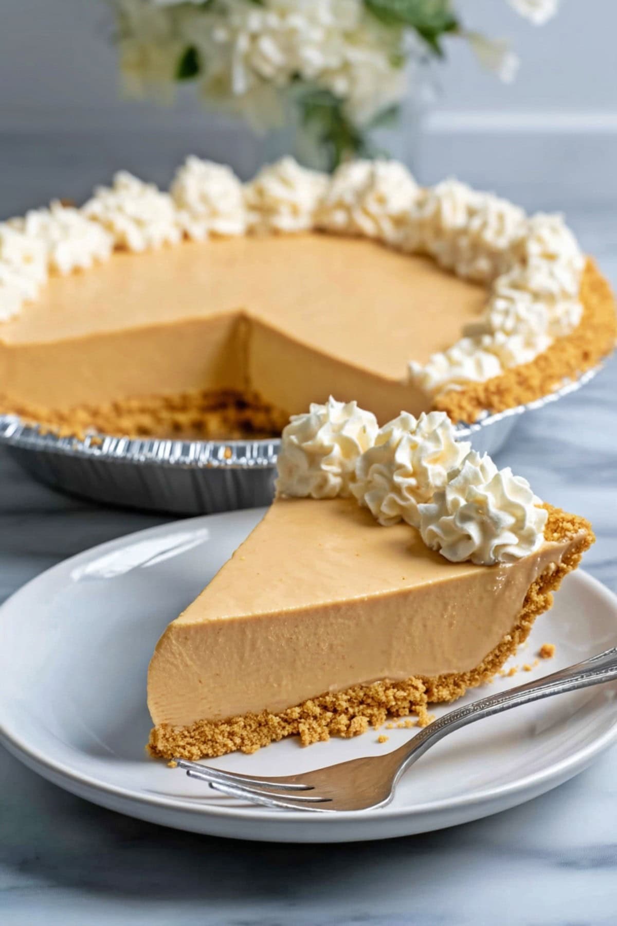 Dolly Parton's Peanut Butter Pie on a plate, with the rest of the pie in the background.
