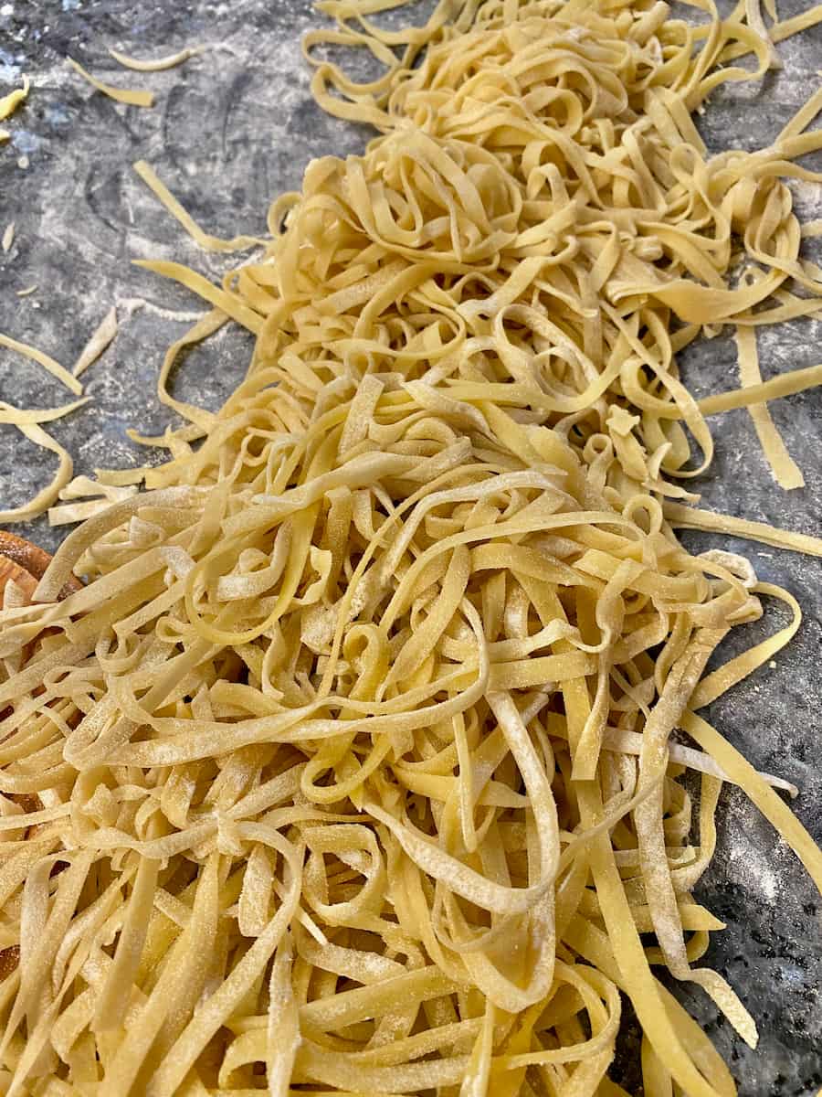 Homemade noodles drying on the counter with a dusting of flour