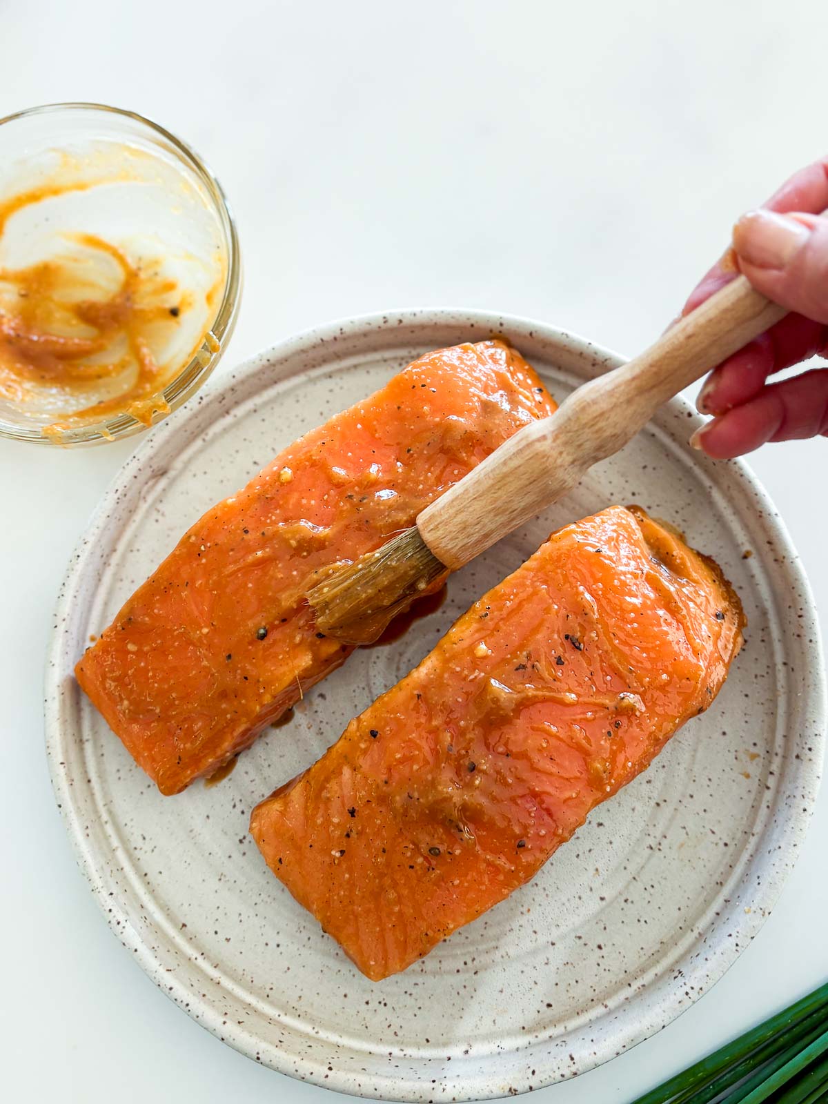 Hand brushing marinade onto the salmon filets.