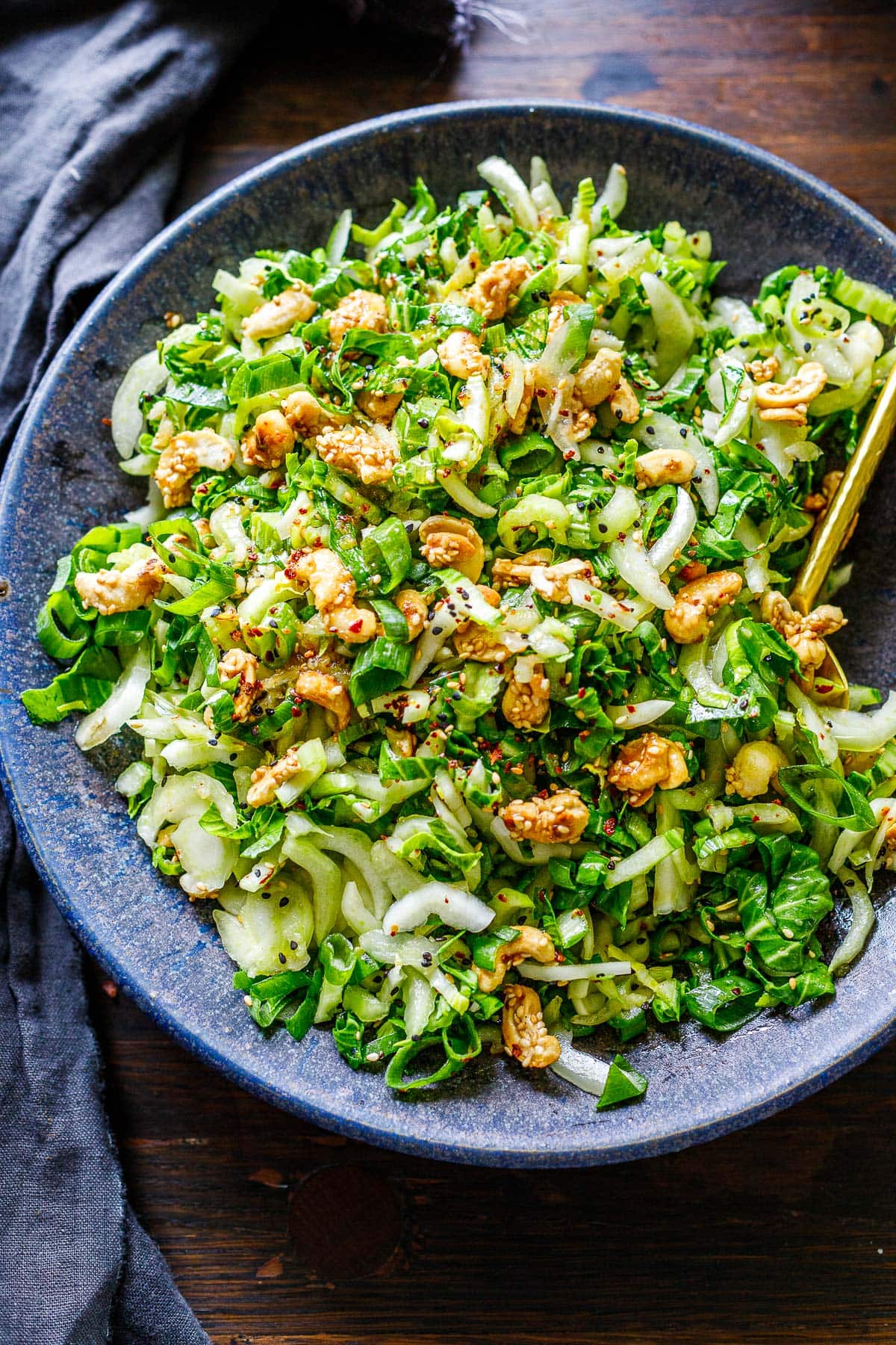 A vibrant bowl of bok choy salad topped with crunchy cashew brittle and ginger dressing.