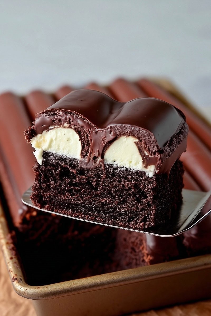 A slice of bumpy cake lifted from its pan.