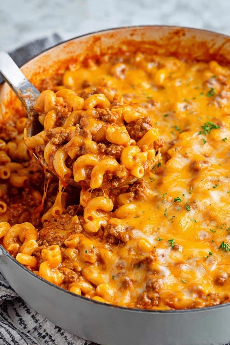 Beefaroni topped with melted cheese in a pot.