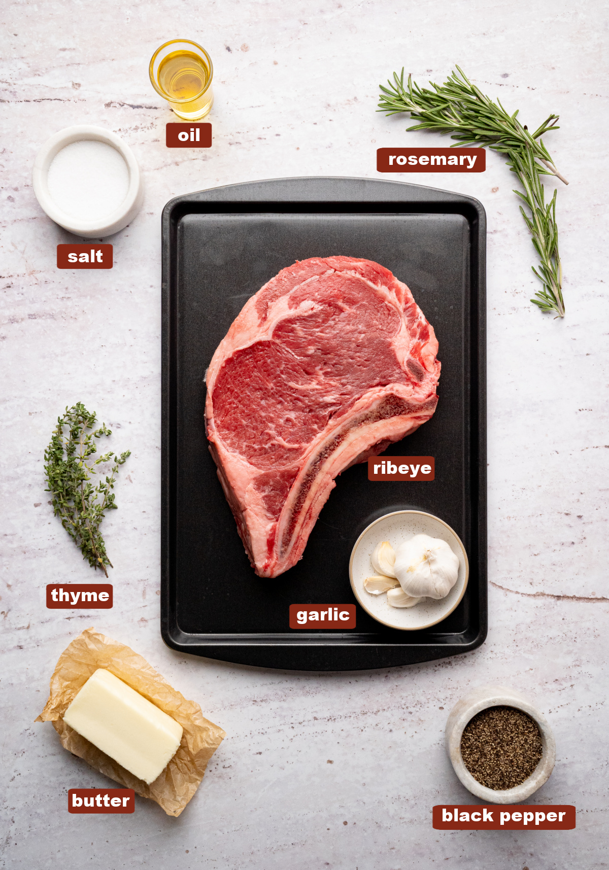 All of the ingredients for ribeye steak in bowls or a dish on a countertop.