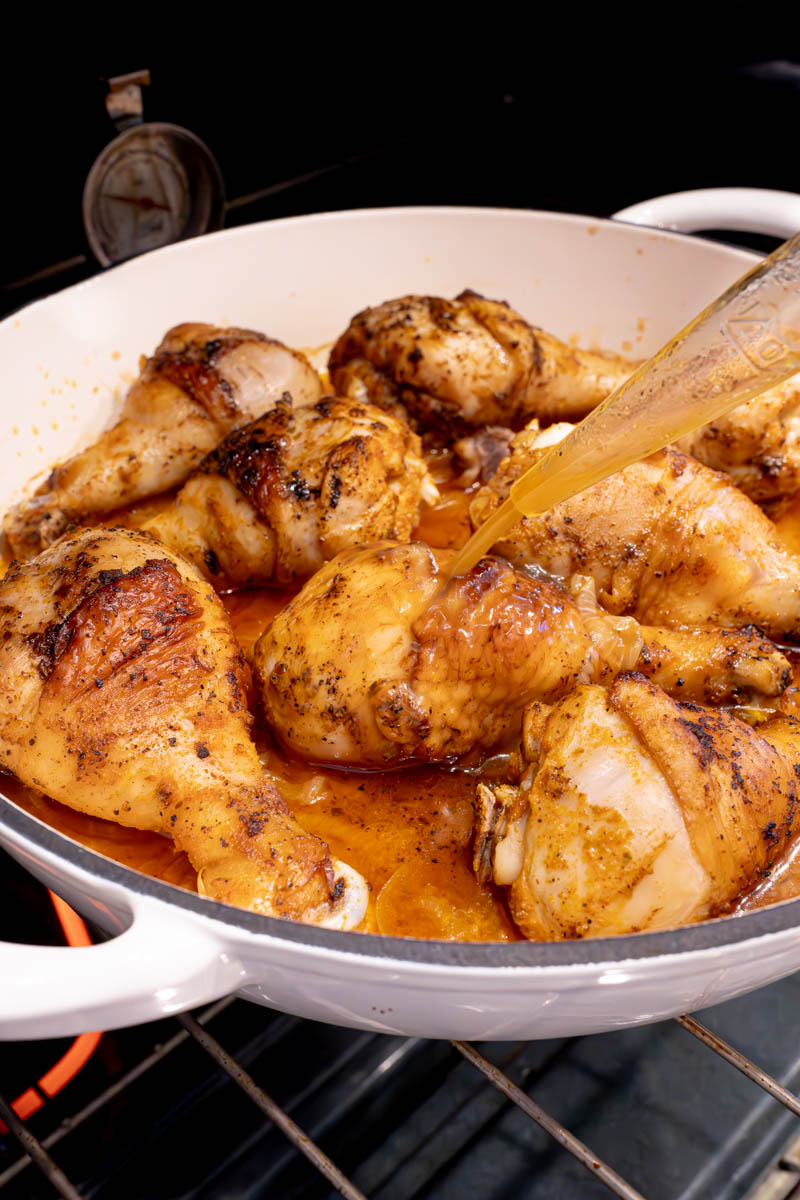 Basting the roasted chicken legs with the onion broth before serving.