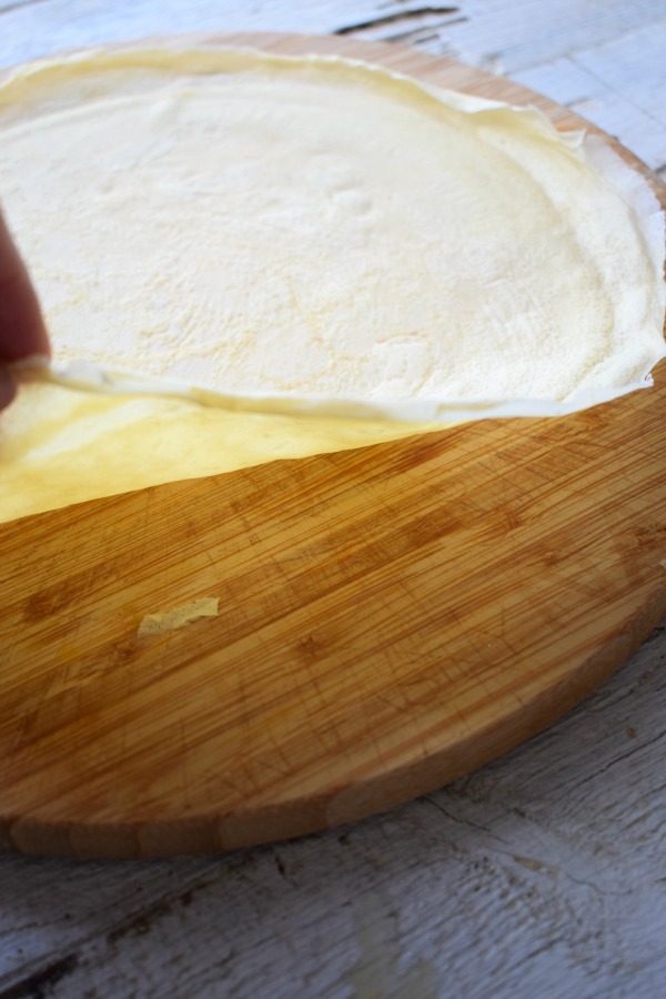 Cooked crepes on a wooden platter.
