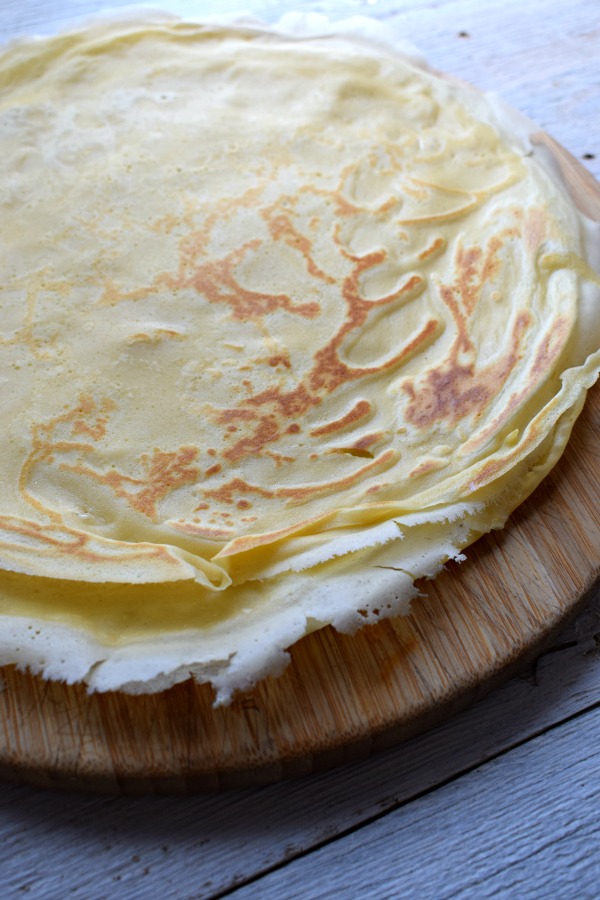 Crepes on a wooden platter.