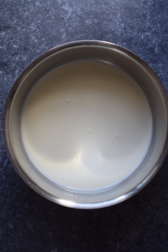 Adding cream to a saucepan to make ganache.