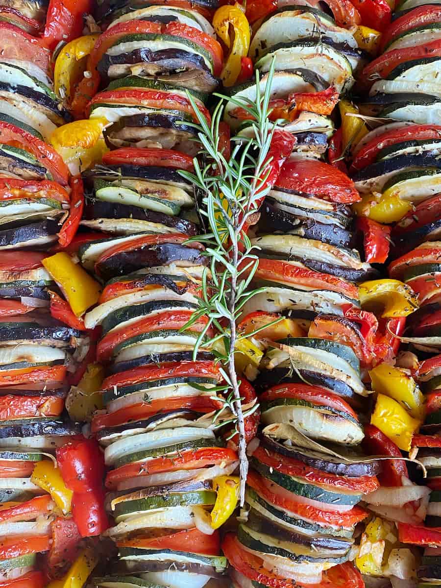 Stacked roasted summer vegetables in a French tian
