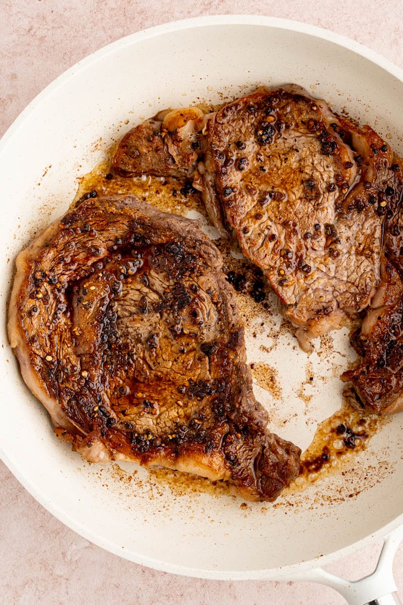 Searing the ribeye steaks in the pan before making the cream sauce