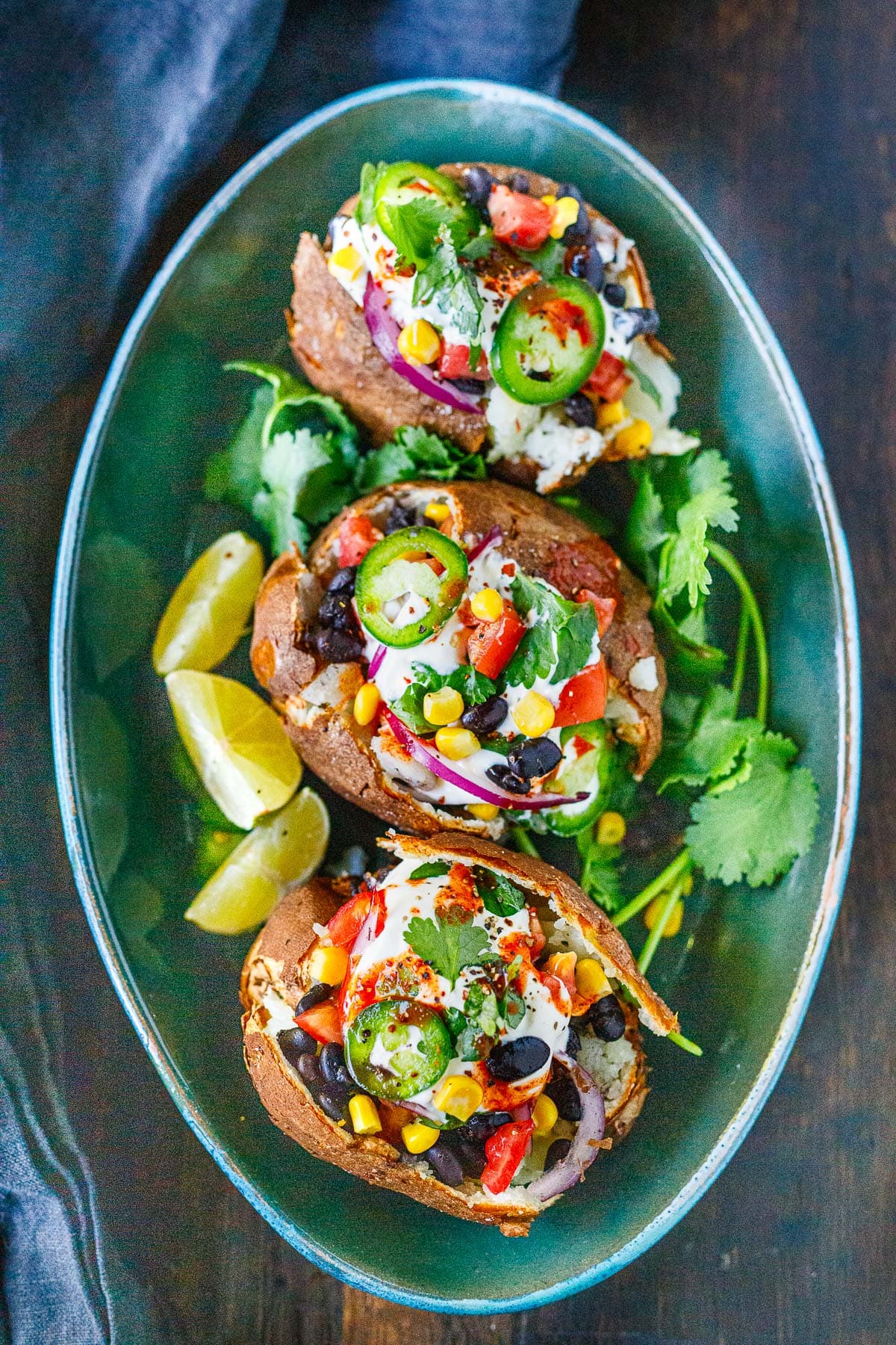 Mexican stuffed baked potatoes on a green platter